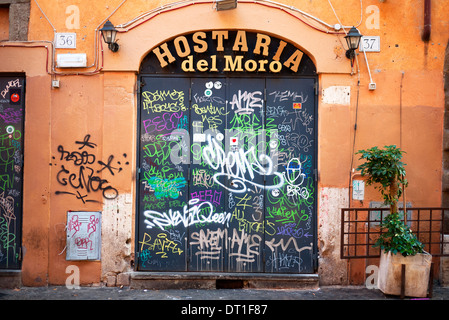 Graffiti gesprüht auf Türen in Trastevere, Rom, Italien. Stockfoto