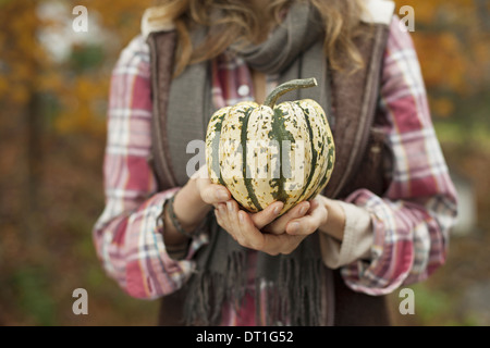 Bio Bauernhof Frau hält eine große gestreifte squash Gemüse Stockfoto