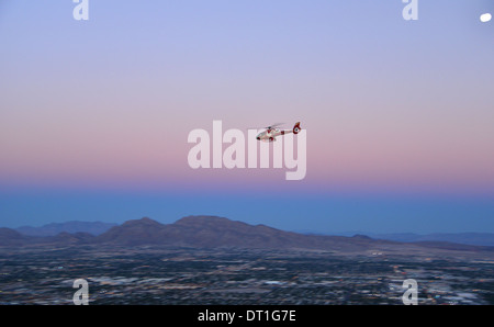 Touristischen Hubschrauber zurück nach Las Vegas vom Grand Canyon in der Abenddämmerung, gesehen vom Stratosphere Hotel Stockfoto