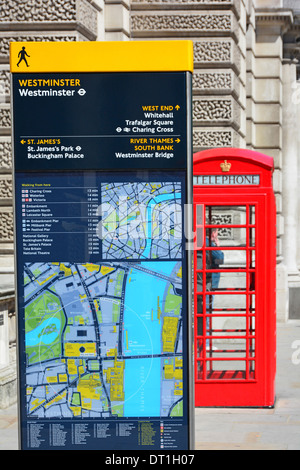 Gut lesbare London Straßenschild Inserat Reisezielen mit roten Telefonzelle jenseits in Westminster in der Nähe Stockfoto