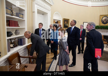 US-Präsident Barack Obama weist darauf hin mehrere patent-Modelle beim Treffen mit dem amerikanischen Nobelpreisträger 2013 und deren Ehepartner im Oval Office des weißen Hauses 19. November 2013 in Washington, DC. Stockfoto