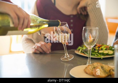 Ein junger Mann und eine Frau sitzen zusammen Essen und trinken Wein Stockfoto