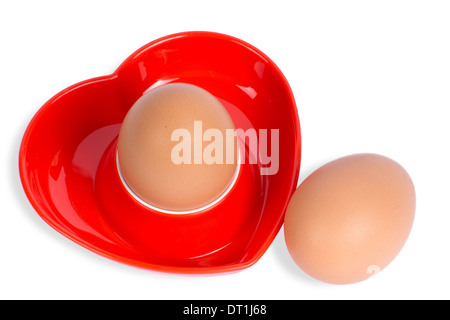 Isolierte Ei in einem roten herzförmigen Eierbecher Stockfoto