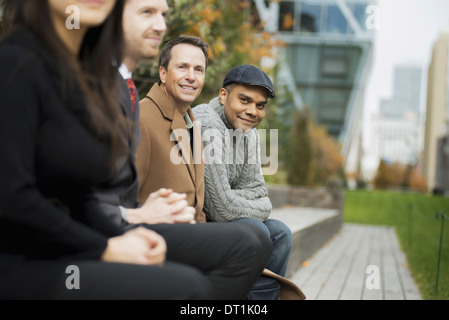 sitzen auf einer Bank Männer und Frauen Stockfoto