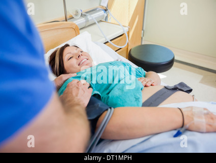 Glücklich schwangere Frau im Krankenhausbett liegend Stockfoto