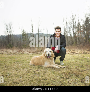 Ein Mann unter freiem Himmel an einem Wintertag, einen golden Retriever Hund streicheln Stockfoto