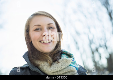 Eine junge Frau in einem Schal und Mantel außerhalb an einem Wintertag Stockfoto