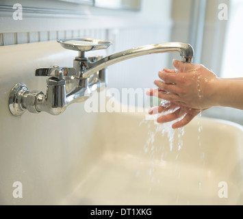 Ein Junge seine Händewaschen unter dem Bad Wasserhahn Stockfoto