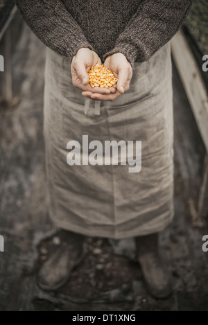 Frühling, einen Mann hält eine Handvoll von Pflanzensamen in seiner hohlen Hand Einpflanzen Stockfoto