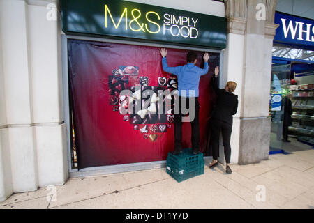 London UK. 6. Februar-204. Personal an Marks & Spencer legte ein Poster mit einer herzförmigen Schachtel Pralinen wie Geschäfte bereit zum Valentinstag, die im Zusammenhang mit der romantischen Liebe bekommen durch die Dekoration der Fenster Ladenfronten mit Herzen Credit: Amer Ghazzal/Alamy Live-Nachrichten Stockfoto