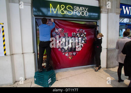 London UK. 6. Februar-204. Personal an Marks & Spencer legte ein Plakat herzförmige Schachtel Pralinen wie Geschäfte bereit zum Valentinstag, die im Zusammenhang mit der romantischen Liebe bekommen durch die Dekoration der Fenster Ladenfronten mit Herzen Credit: Amer Ghazzal/Alamy Live-Nachrichten Stockfoto