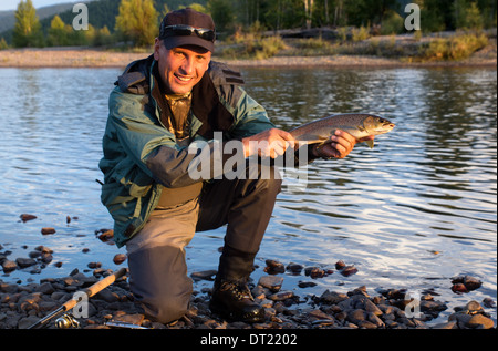 Fischer mit Forellen Fischen am Ufer des Flusses Uur im Norden der Mongolei Stockfoto