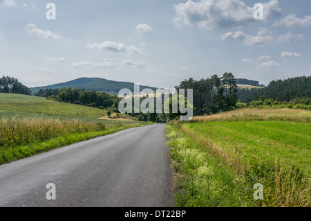 Eine Straße durch die Landschaft an einem Sommertag Stockfoto