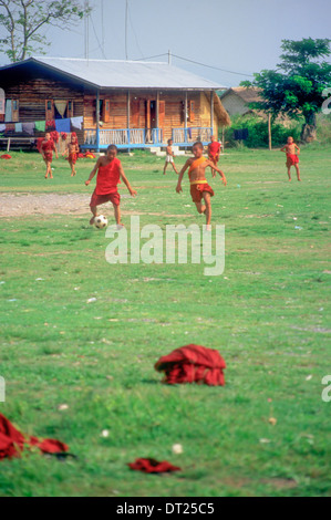 Junge buddhistische Mönche spielen Fußball (Fußball) am Inle-See, Birma (Myanmar). Ihre Gewänder liegen auf dem Boden verworfen. Stockfoto