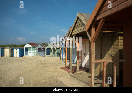 Bunte hölzerne Strandhütten entlang des Sandstrandes am West Wittering, nahe der Mündung des Hafen von Chichester, West Sussex, UK. Stockfoto