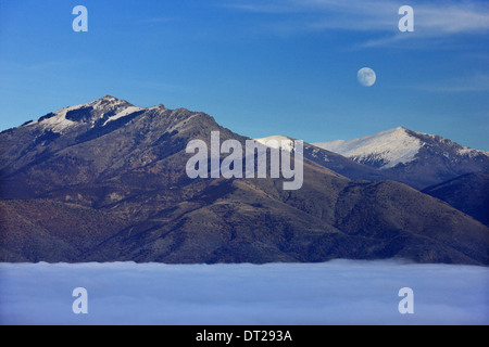 Moon Rising über Varnoundas Berg. Unter den Wolken ("groß") Megali Prespa See, Florina, Mazedonien. Stockfoto