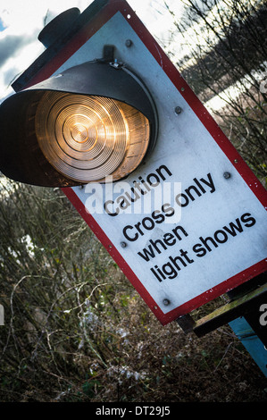 Vorsicht überqueren nur wenn Lichtshows Schild mit Bahngleisen im Hintergrund Stockfoto