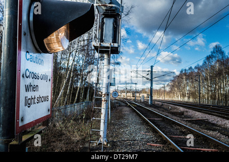 Vorsicht überqueren nur wenn Lichtshows Schild mit Bahngleisen im Hintergrund Stockfoto