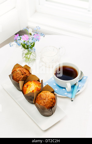 Drei Muffins und Kaffee am Frühstückstisch am Morgen Stockfoto