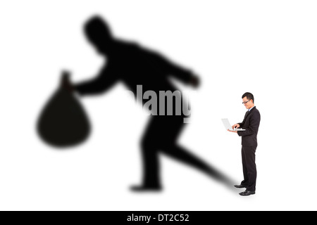 Geschäftsmann mit Laptop mit Dieb Schatten Stockfoto