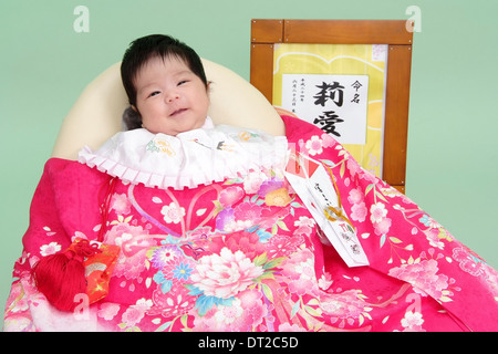 Miyamairi Bild eines kleinen Mädchens mit Namen auf Kanji in einem Rahmen geschrieben Stockfoto