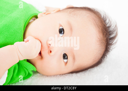 Baby mit Finger saugen und auf dem Handtuch liegend Stockfoto