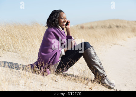 USA, Illinois, Waukegan, Portrait von junge Frau sitzt im Rasen und Handy Stockfoto