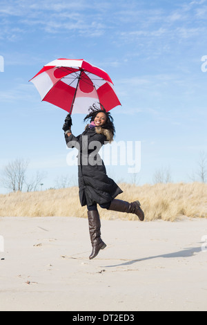 USA, Illinois, Waukegan, Porträt der jungen Frau tanzt mit Regenschirm