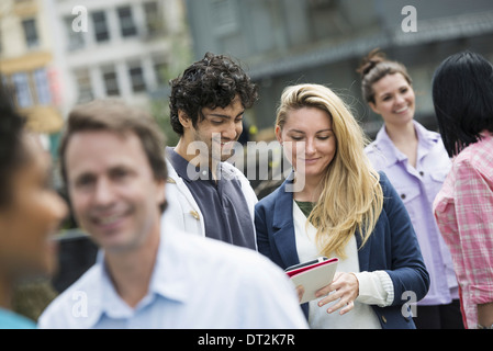 ein paar in der Mitte, Blick auf ein Handy Stockfoto