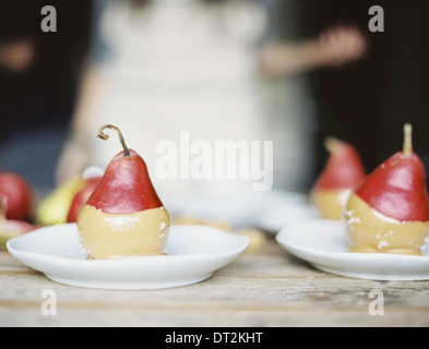 Eine Frau in einer Küche frische Bio Birnen tauchte in einer Sauce zum Nachtisch auf Platten gelegt Stockfoto