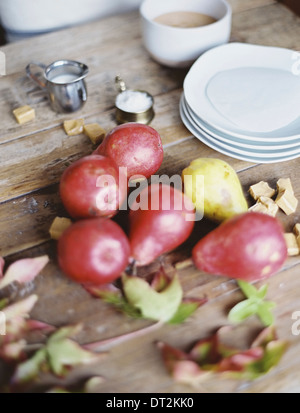 Eine häusliche Küche Tischplatte A kleine Gruppe von frischen Bio-Birnen und einen Stapel von weißen Platten Stockfoto