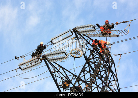 Arbeiter an Strommasten in Italien. Wartungsarbeiten von einer Hochspannungs-Leitung. Stockfoto