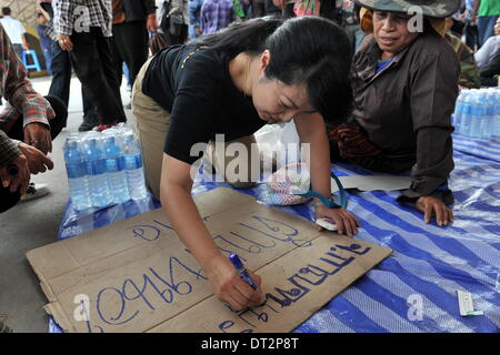 Bangkok, Thailand. 7. Februar 2014. Ein Thai Bauer schreibt Parolen während einer Kundgebung auf dem Gelände des Handelsministerium Thailands in der Provinz Nonthaburi, am Stadtrand von Bangkok, Thailand, 7. Februar 2014. Thai-Reis-Landwirte, die aus Protest gegen eine Verzögerung bei den Zahlungen für ihre neuesten Ernte unter der Regierung Reis Verpfändung Programm am Freitag gesammelt haben zog eine Frist für die Regierung vor 15 Februar bezahlen. Bildnachweis: Gao Jianjun/Xinhua/Alamy Live-Nachrichten Stockfoto