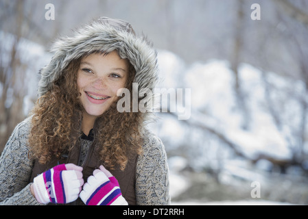 Winterlandschaft mit Schnee auf dem Boden A junge Mädchen in eine Wollmütze mit Ski-Handschuhe auf Stockfoto