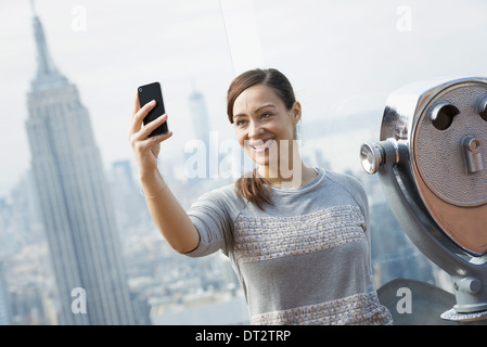 Blick über CityA Frau mit ihrem Smartphone zu um fotografieren, die Aussicht Stockfoto