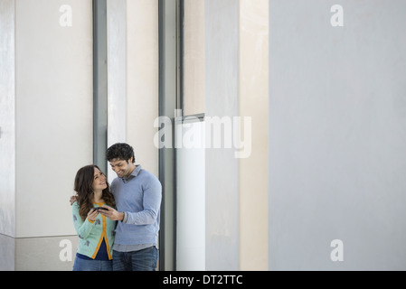 Urban Lifestyle A junges Paar Mann und Frau nebeneinander auf einem Mobiltelefon Stockfoto