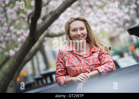 Blick über CityA junge Frau mit langen blonden Haaren im Freien in einem Stadtpark Stockfoto