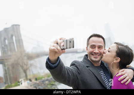 Brooklyn Bridge überqueren den East River ein paar Aufnahme eines Bildes mit einem Telefon eine selfy von sich selbst Stockfoto