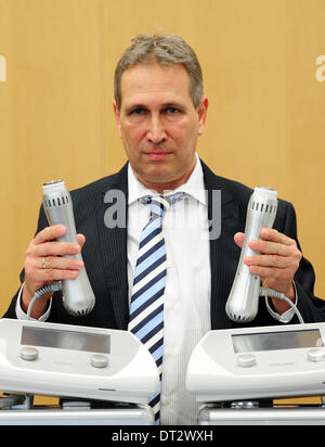 Frankfurt Main, Deutschland. 7. Februar 2014. Michael Zimmer, Manager von Zimmer MedizinSysteme GmbH hält den ersten Preis während der Zeremonie oder der Witz-Preis "Plagiarius", die besonders schamlose Produktkopien auf der Konsumgüter Messe Ambiente in Frankfurt Main, Deutschland, 7. Februar 2014 gegeben ist. Das ursprüngliche Shockwave "ZWave" Therapiegerät von der deutschen Firma Zimmer MedizinSysteme (L) und die Kopie von chinesischen Unternehmen "Shenzhen PRT Import Export Co." Foto: DANIEL REINHARDT/Dpa/Alamy Live News Stockfoto
