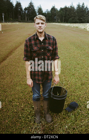 Eine Cranberry Farm in Massachusetts Kulturen in die Felder A junger Mann arbeiten auf dem Land, die Ernte der Erntegutes Stockfoto