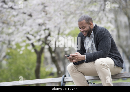 Ein junger Mann Überprüfung sein Telefon und SMS Stockfoto