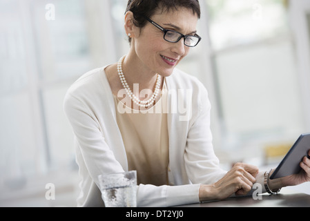 Junge Berufstätige an Arbeit eine Frau in einem Büro mit einem digitalen tablet Stockfoto