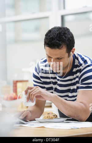 Ein Büro oder Wohnung innen in New York City A Mann in einem gestreiften t-Shirt stützte sich auf die Frühstücks-Bar Stockfoto