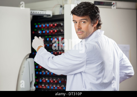 Forscher, die Flaschen in Blut Kultur Instrument platzieren Stockfoto