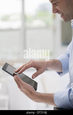 Profis im Büro A Licht und luftig Ort der Arbeit einen Mann in einem weißen Hemd mit einem digitalen tablet Stockfoto