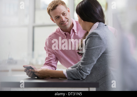 Profis im Büro ein hellen und luftiger Ort der arbeiten zwei Personen sitzen an einem Schreibtisch mit einem digitalen tablet Arbeitskollegen Stockfoto