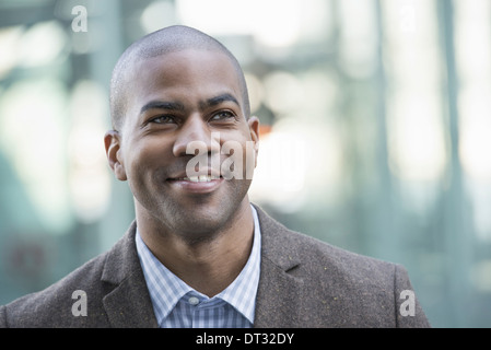 Ein Mann in Anzug und Krawatte lächelnd und Blick in die Ferne Stockfoto