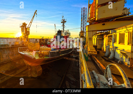 Schiff im Trockendock bei Sonnenaufgang - Werften in Danzig, Polen. Stockfoto