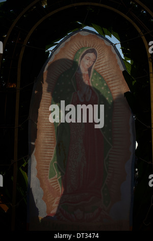 Die Silhouette eines Pilgers wird in ein Bild der Jungfrau von Guadalupe zu unserer lieben Frau von Guadalupe Basilica, Mexiko gesehen. Stockfoto