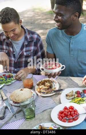 Eltern und Kindern helfen, sich auf frisches Obst und Gemüse Stockfoto